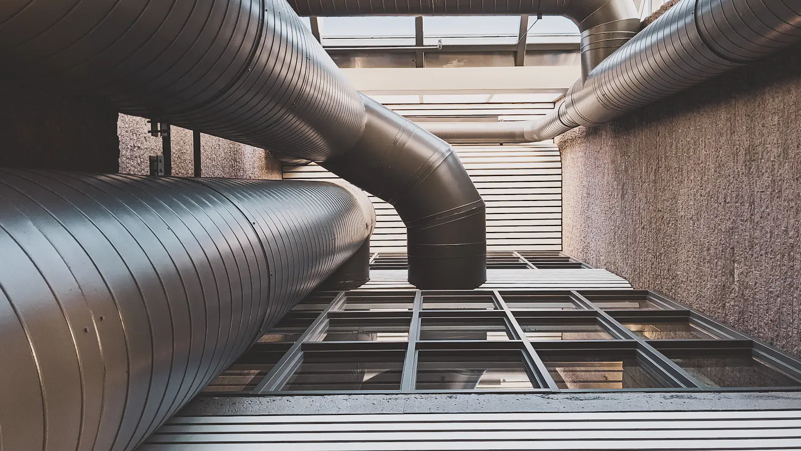 Large metal ducts running along a building