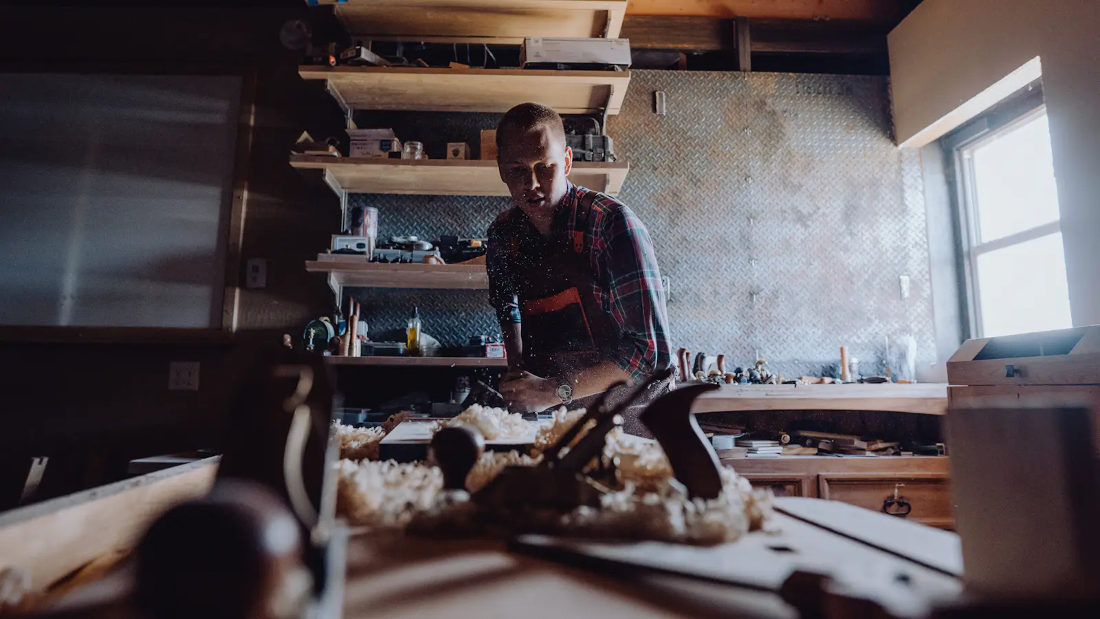 A tradesman at his workbench, tools laid out in front of him