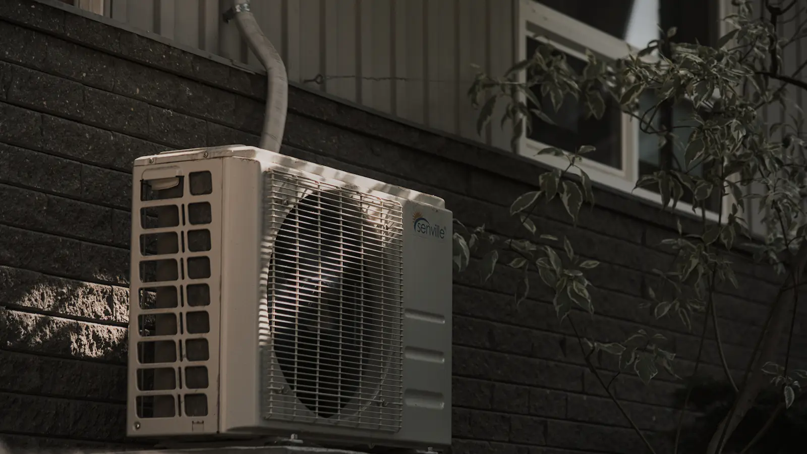 An air conditioner mounted on a brick wall